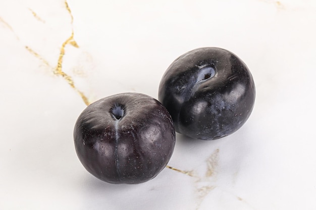 Photo two ripe sweet black plums isolated