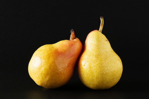 Photo two ripe williams pears on black background.