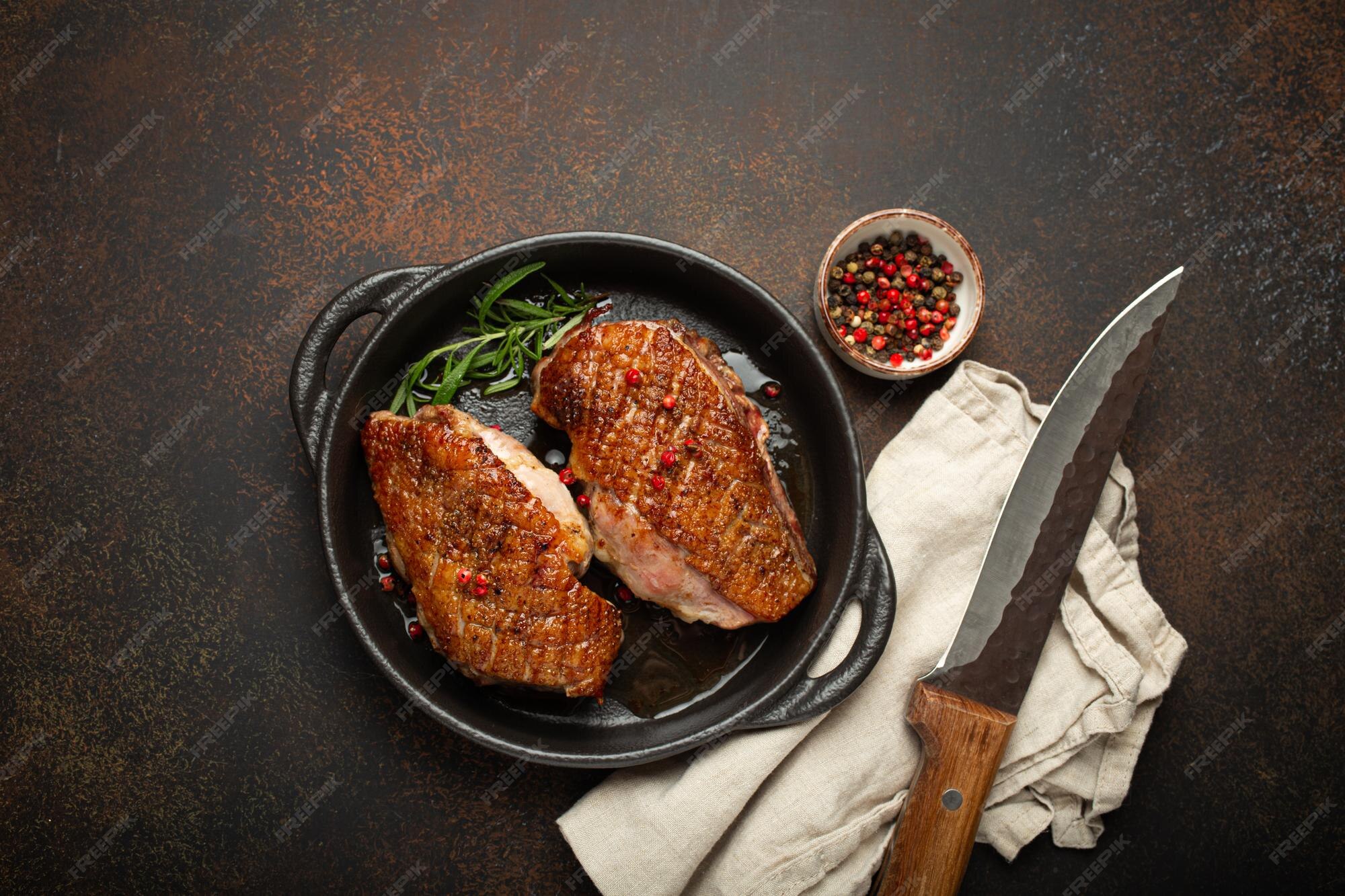 Premium Photo | Two roasted duck breast fillets with crispy skin with