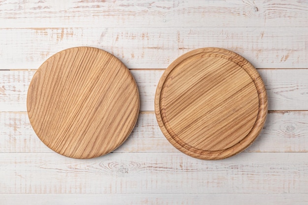 Two round cutting boards with edging on a white wooden table mockup of a food background with copy space side view