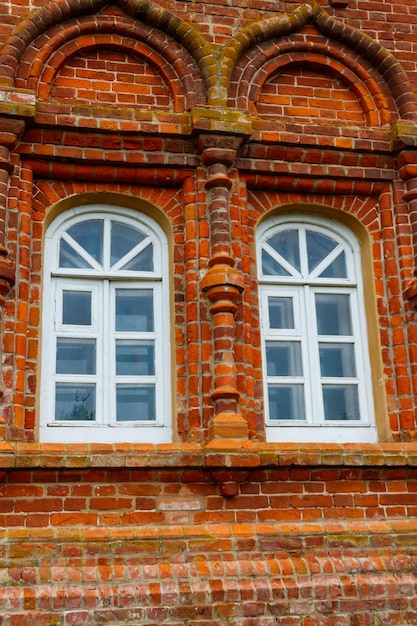 Two rounded windows on old red brick wall