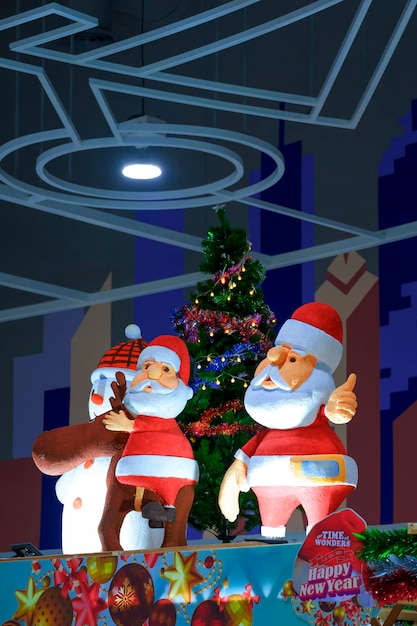 Two Santa Claus dolls and Christmas decorations with lighting display inside of department store