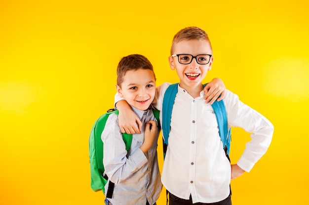 Two school friends stand in an embrace and smile