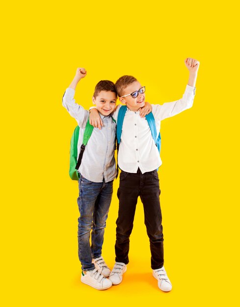 Two school friends stand in an embrace and smile