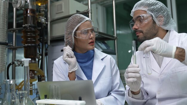 Two scientist in professional uniform working in laboratory for chemical and biomedical experiment