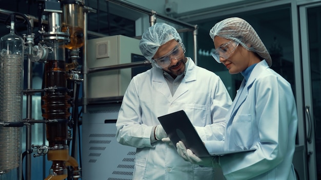 Two scientist in professional uniform working in laboratory for chemical and biomedical experiment