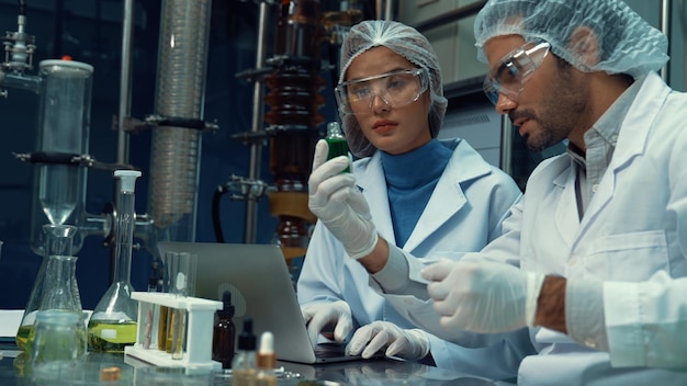 Two scientist in professional uniform working in laboratory