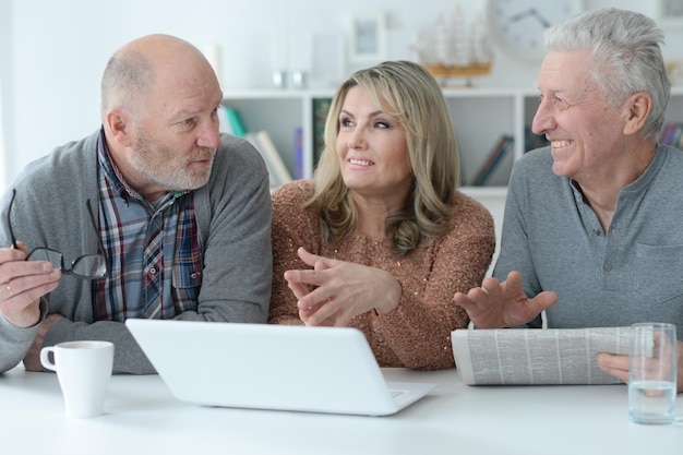 Photo two  senior men and woman using laptop at home