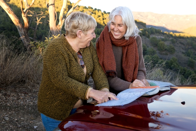 Две пожилые женщины консультируются с картой во время поездки на природу