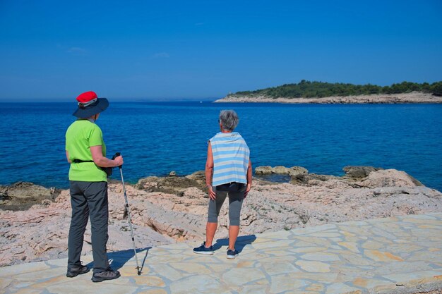 Two senior women walking along the sea shore