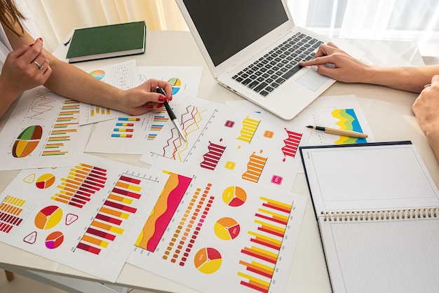 Two serious business ladies working on design charts at a spacious table