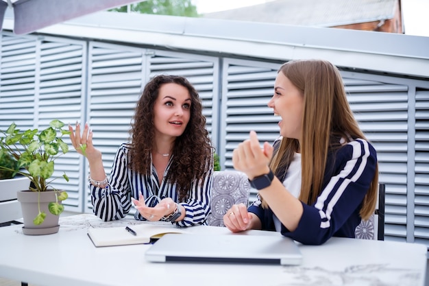 Фото Две серьезные девушки-предпринимательницы обсуждают бизнес-проект, работают вместе в офисе, серьезная женщина-консультант и клиент разговаривают на встрече, целеустремленные коллеги-руководители делятся идеями