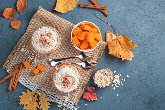 Two servings with pumpkin parfait and cream on a dark blue background