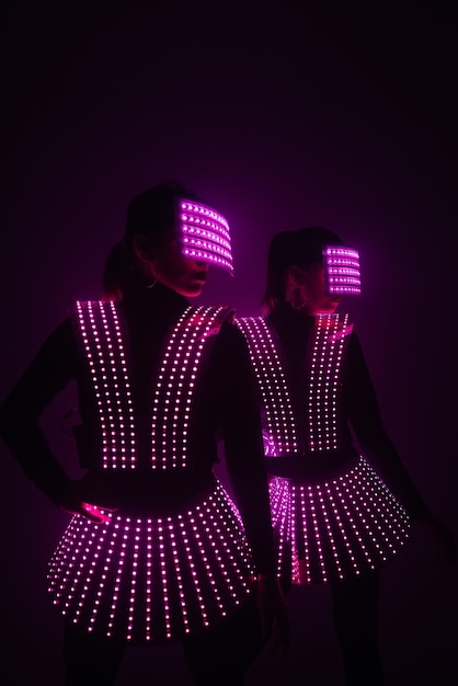 Two sexy disco dancers move in UV costumes. Parties and dances.