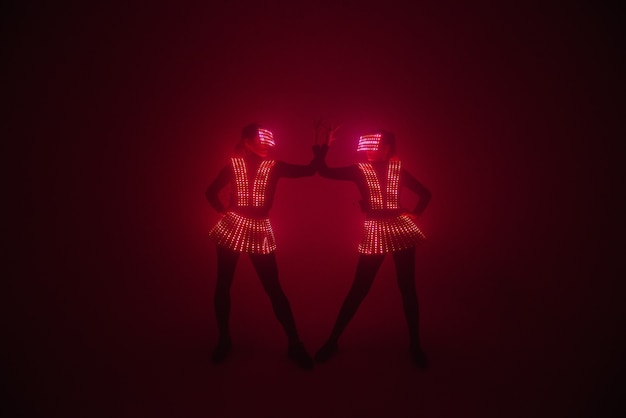 Two sexy disco dancers move in uv costumes. parties and\
dances.