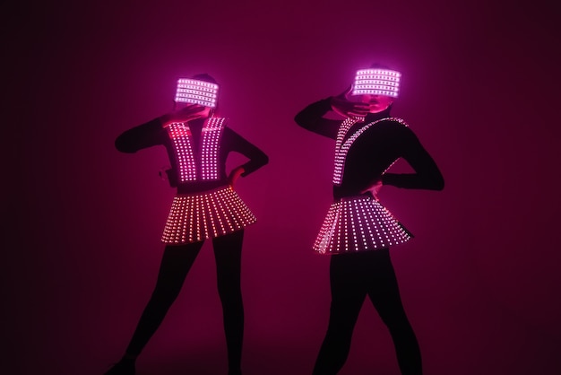두 명의 섹시한 디스코 댄서가 UV 의상을 입고 움직입니다. 파티와 춤.