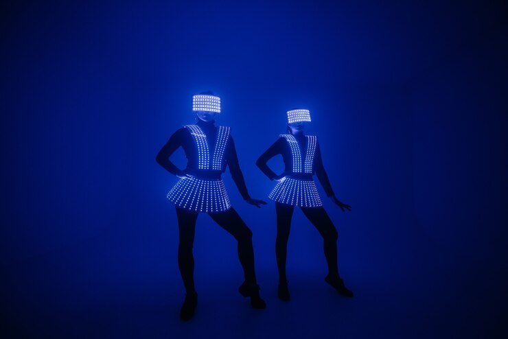 Two sexy disco dancers move in UV costumes. Parties and dances.