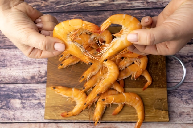 Photo two shrimps held by a woman's hands form the shape of a heart