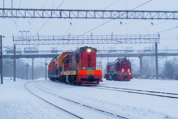 Two shunting diesel locomotives on a branch line in winter during a snowfall