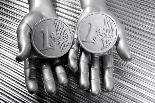 Two silver euro coins in futuristic robot hands