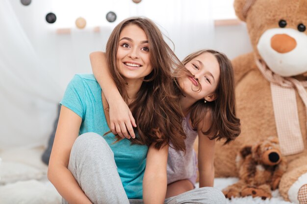 Two sisters having fun together in children room