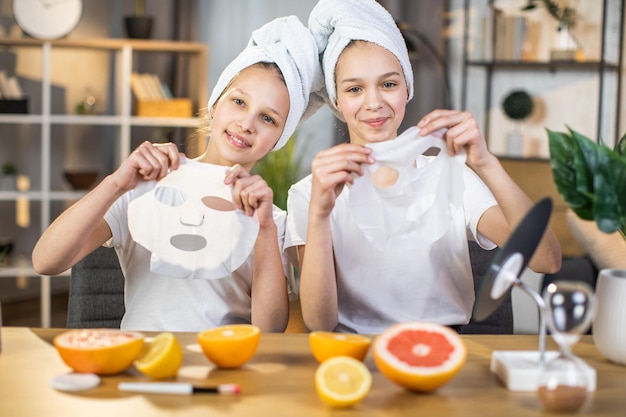 Две сестры держат за столом витаминную маску для лица