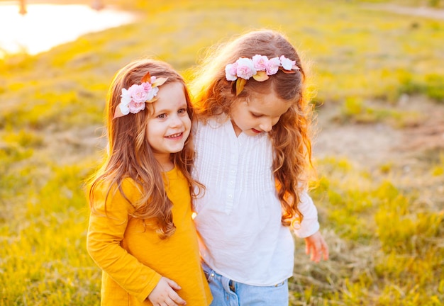 Two sisters kids on sunset outdoor have fun