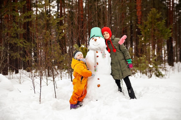 2 人の姉妹が冬に雪だるまを作る