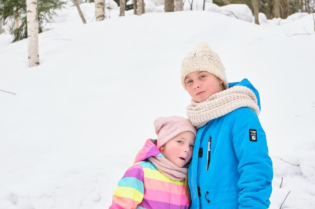 Two sisters play cute outside on a winter day