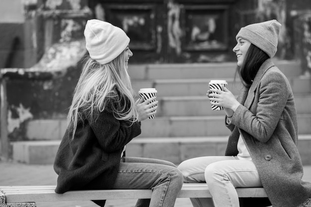 Photo two sisters relaxing and drinking coffee coffee break coffee to go