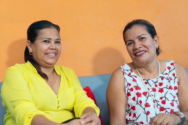 Two sisters sitting together on the sofa at home