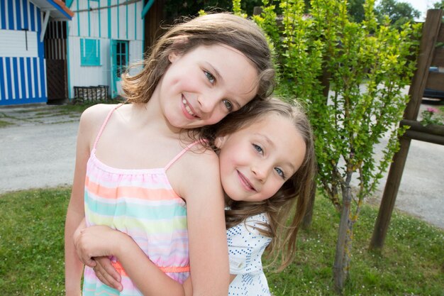 Photo two sisters in summer hug and love family in vacation day