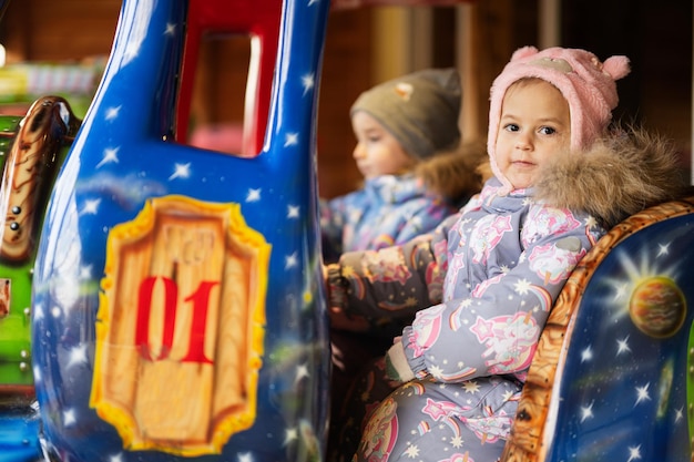 Two sisters in train carousel in amusement park