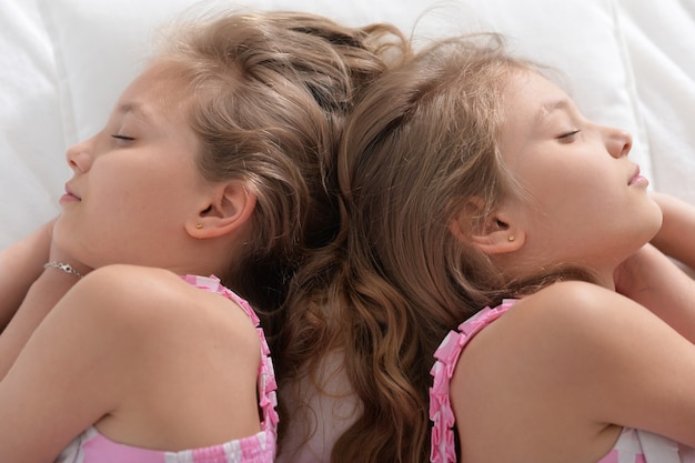 Two sisters twins sleeping in their bad