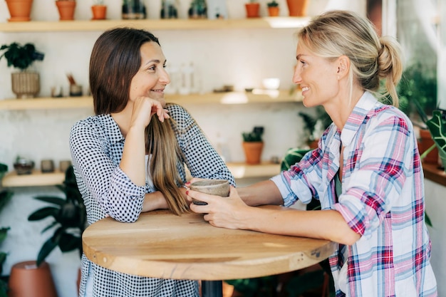 two slender young women friends communicate in a cozy cafe