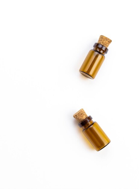 Two small bottles with gold colored corks on a white background