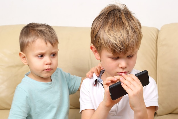 Two small boys looking at cell phone
