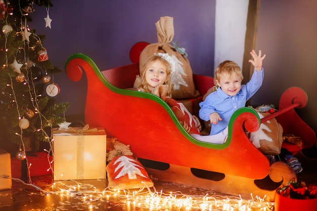 Due bambini piccoli vicino con un albero di natale