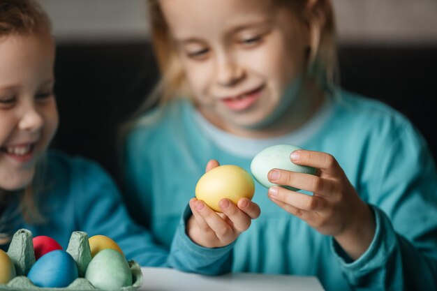 Two small cute girls with amazing smile playing in a game with eggs beat eggs in a fight