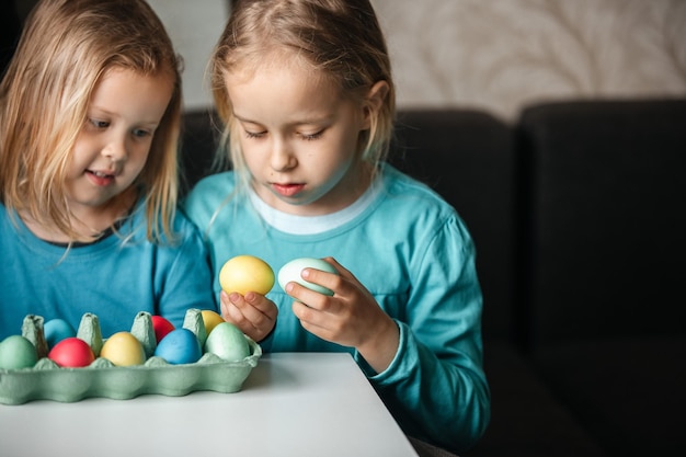 Two small cute girls with amazing smile playing in a game with eggs beat eggs in a fight