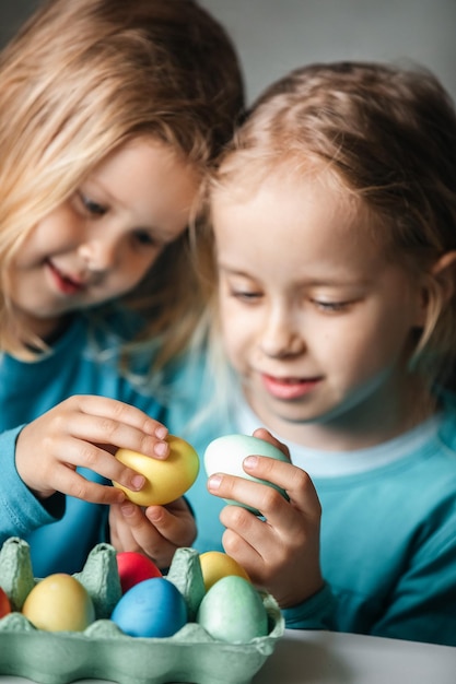 Two small cute girls with amazing smile playing in a game with eggs beat eggs in a fight