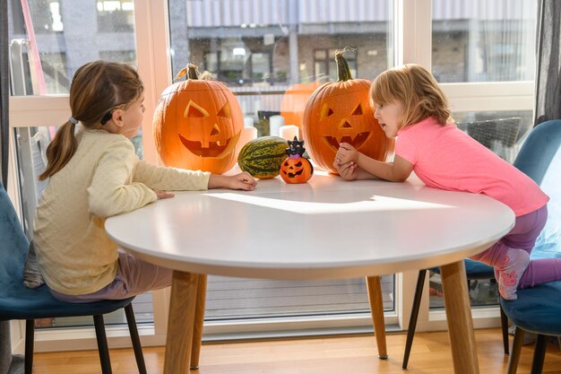 Two small girls looking at Halloween pumpkins