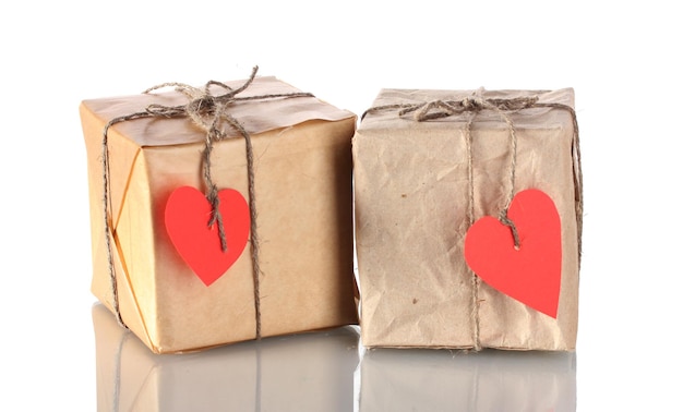 Two small parcels with blank heart-shaped labels isolated on white