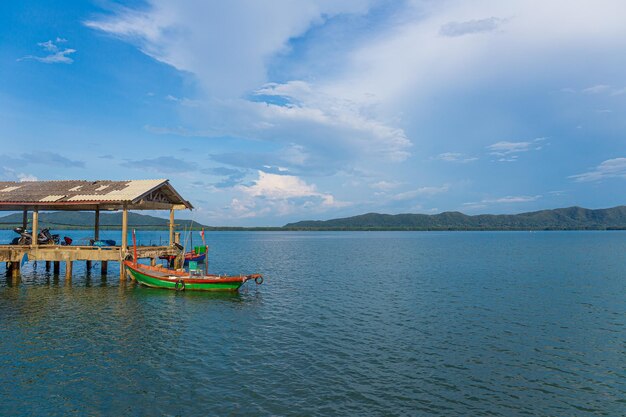 two small traditional fishing boats sea and hillside views fish cages blue sea and sky