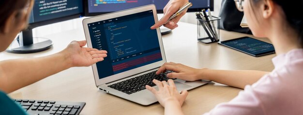 Photo two smart cooperative computer engineers working together as teamwork to solve program code while computer screen displayed program code laptop web development programer java script burgeoning