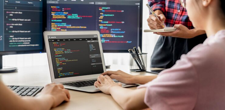 Photo two smart cooperative computer engineers working together as teamwork to solve program code while computer screen displayed program code laptop web development programer java script burgeoning