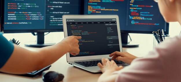 Two smart cooperative computer engineers working together as teamwork to solve program code while computer screen displayed program code Laptop web development programer java script Burgeoning