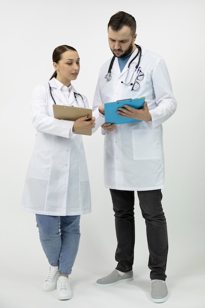 Two smart male and female doctors discuss medicine prescription on clipboard