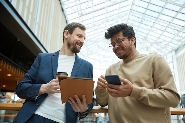 デバイスを使用して2人の笑顔のビジネスマン