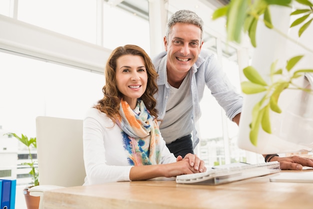 Two smiling casual designers working together